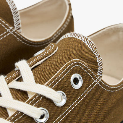 Converse Chuck 70 Canvas. Close-up of white contrast stitching, silver eyelets, and white laces on bog down canvas sneakers.