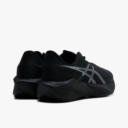 ASICS NOVABLAST 6. Rear three-quarter view of black running shoes with grey ASICS stripes, padded heels and sculpted midsoles.