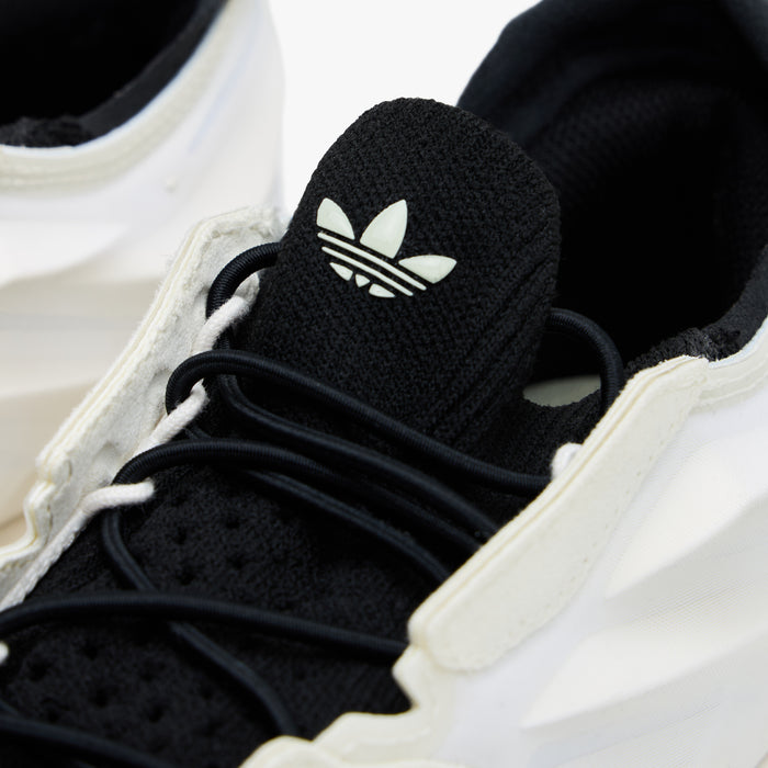 adidas Terra Mono. Close-up of white, off white and black sneaker showing black laces, black tongue with adidas Trefoil and sculpted upper.