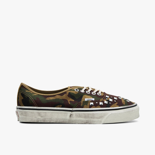 Side Vans LX Authentic 44. Side view of woodland camo canvas sneakers with silver pyramid studs and distressed white midsole.