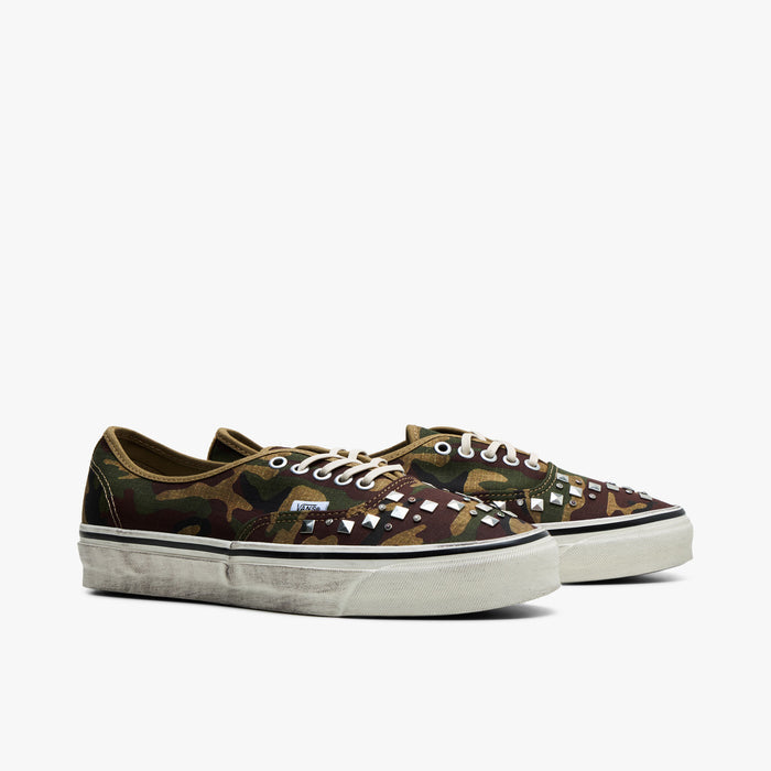 Vans LX Authentic 44. Three-quarter view of woodland camo sneakers showing studded toe vamps and cream laces.