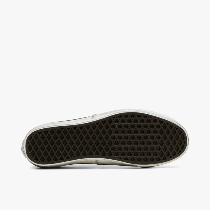 Vans LX Authentic 44. Bottom view of woodland camo sneakers showing dark brown rubber waffle outsole pattern.