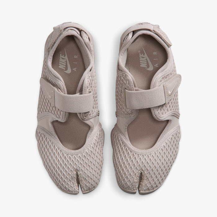 Nike Women's Air Rift. Top view of pair of Cream II split-toe shoes showing midfoot hook-and-loop straps, textile lining, and white inner sole logos.