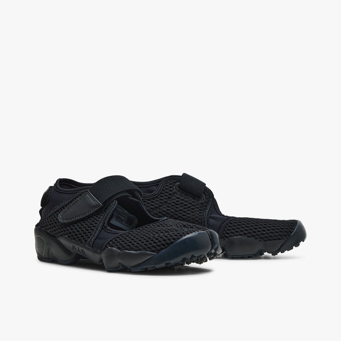 Nike Women's Air Rift Mesh. Low-angle three-quarter view of pair of black split-toe shoes showing mesh construction and flexible soles.